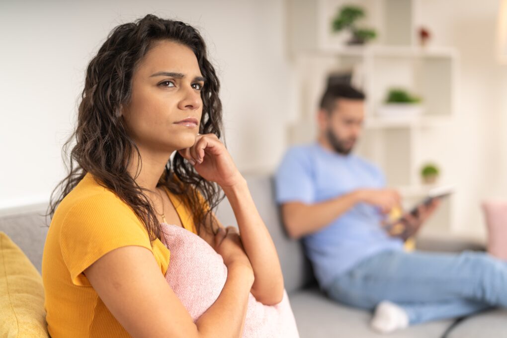 Serious woman lost in her thoughts while sitting next to her partner | Source: Shutterstock