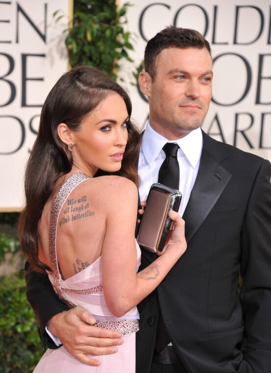 Megan Fox, in a light pink dress with an open back and a large tattoo, with Brian Austin Green in a black suit.